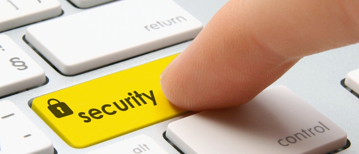 dedo humano clicando em uma tecla amarelo onde está escrito segurança_ilustrando a segurança de dados na industria 4.0